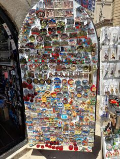 a large display of buttons and magnets on the side of a building in front of a doorway