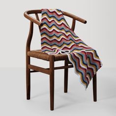 a wooden chair with a crocheted blanket on it