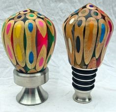 two colorful vases sitting on top of each other in front of a white background