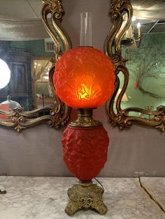 a red lamp sitting on top of a table next to a mirror