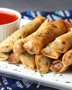 some food is sitting on a white plate and next to a small bowl of sauce