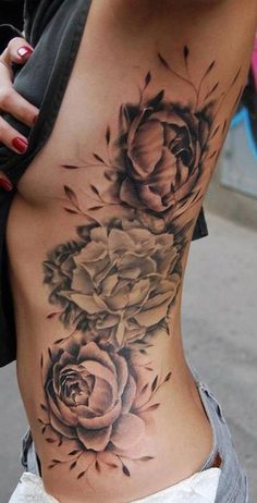 a woman's stomach with roses on it and leaves around the bottom half - back