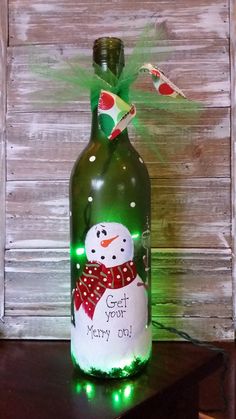 a bottle with a light up snowman on it and the words get you merry on