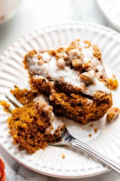 two pieces of cake sitting on top of a white plate with a fork in it