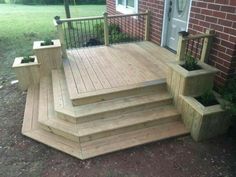 a wooden deck with steps and planters on it