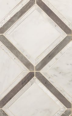 a white marble tile floor with brown and gray lines in the center, on top of it