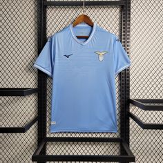 a blue shirt hanging on a rack in front of a wall