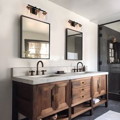 a bathroom with two sinks and mirrors on the wall