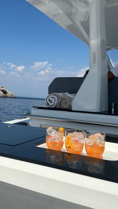 some drinks are sitting on the edge of a boat