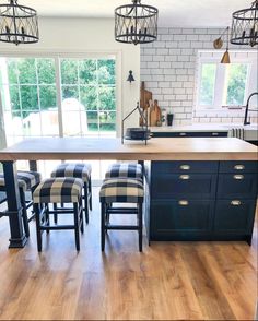 a kitchen island with stools in front of it