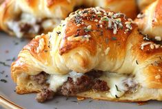 several pastries with meat and cheese are on a plate, ready to be eaten