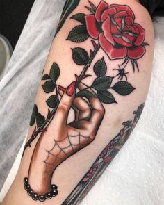 a tattoo with a rose on it and a person's hand holding the flower