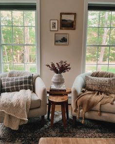 a living room with two couches and a coffee table in front of large windows