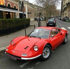 a red sports car is parked on the street