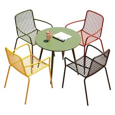 four chairs and a table with a book on it, all in different color combinations