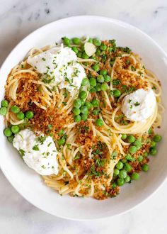 a white bowl filled with pasta and peas