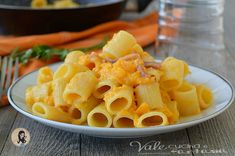 a white plate topped with macaroni and cheese on top of a wooden table