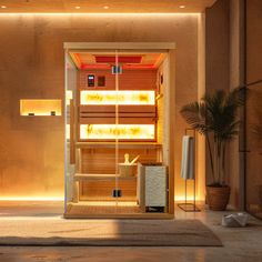 an indoor sauna is lit up at night with the lights on and plants in front