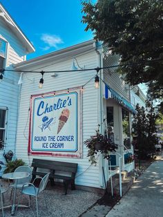 an ice cream shop on the side of a white building with a sign that says charlie's