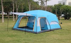 a blue tent sitting on top of a lush green field