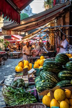 an outdoor market with lots of fruits and vegetables