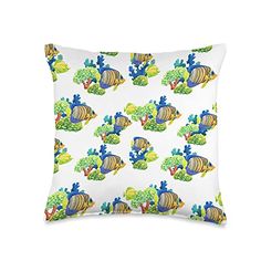 a white pillow with blue and yellow fish on the bottom, surrounded by green plants