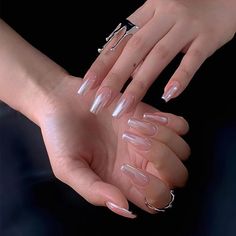 a woman's hands with clear manies and rings on their fingers, holding something in her hand