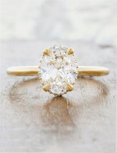 a close up of a ring with a diamond on the top and bottom, sitting on a wooden surface