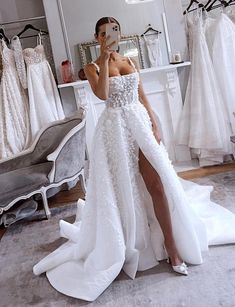 a woman taking a selfie in front of her wedding dress while looking into the mirror