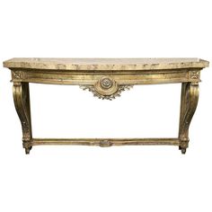 an ornate console table with gold leaf detailing