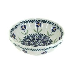 a blue and white bowl with flowers on the rim, sitting in front of a white background