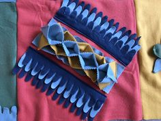 three different types of blue and yellow hair combs on top of a pink blanket