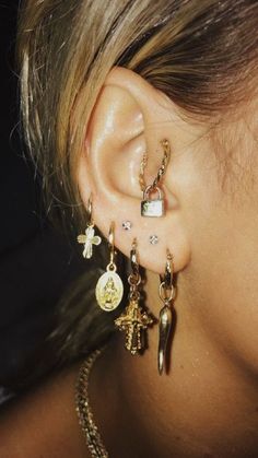 a close up of a person's ear with two different earrings on top of it