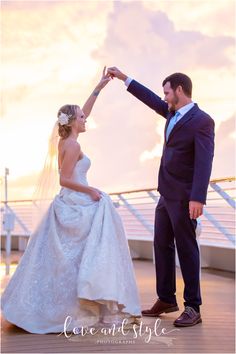 a bride and groom holding hands on the deck of a cruise ship at sunset with their wedding dress blowing in the wind