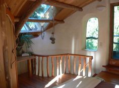 a wooden bench sitting in the middle of a living room next to a large window