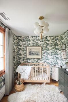 a baby's room with a crib, dresser and rug in the corner