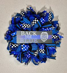 a blue and black mesh wreath with the words back the blue on it's side