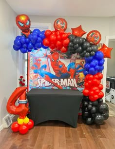 the balloon arch is decorated with spider - man balloons and other decorations for an event