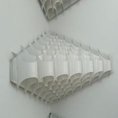 two mirrors are hanging on the wall in an art gallery, one is made out of white paper