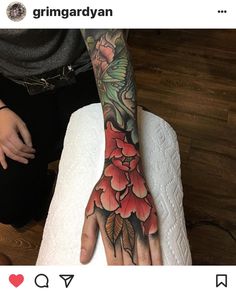 a tattooed hand with flowers on it