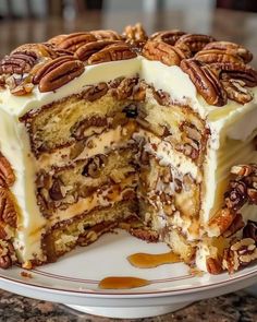 a cake that has been cut in half and is on a plate with pecans