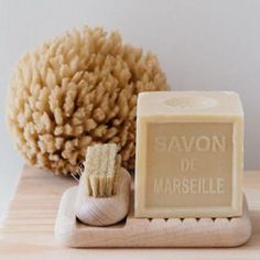 a soap bar sitting on top of a wooden table next to a brush and sponge