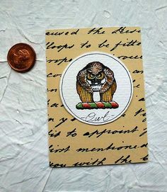 an owl on top of a piece of paper next to a penny