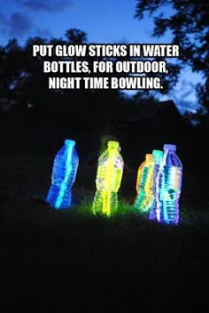 three plastic bottles sitting in the grass at night