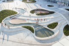 an aerial view of people walking and sitting on benches in the middle of a courtyard