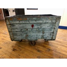 an old blue box sitting on top of a wooden floor