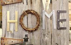 the word home is made out of wood and metal letters with a wreath on top