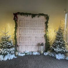 christmas decorations are displayed in front of a sheet of music on the wall behind them