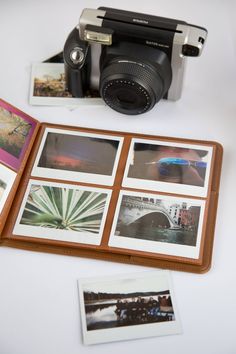 an old camera sitting on top of a table next to some pictures and photos in front of it