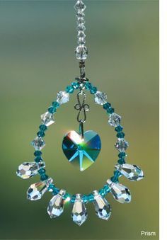 a blue heart hanging from a chain with crystal beads and swarong crystals on it